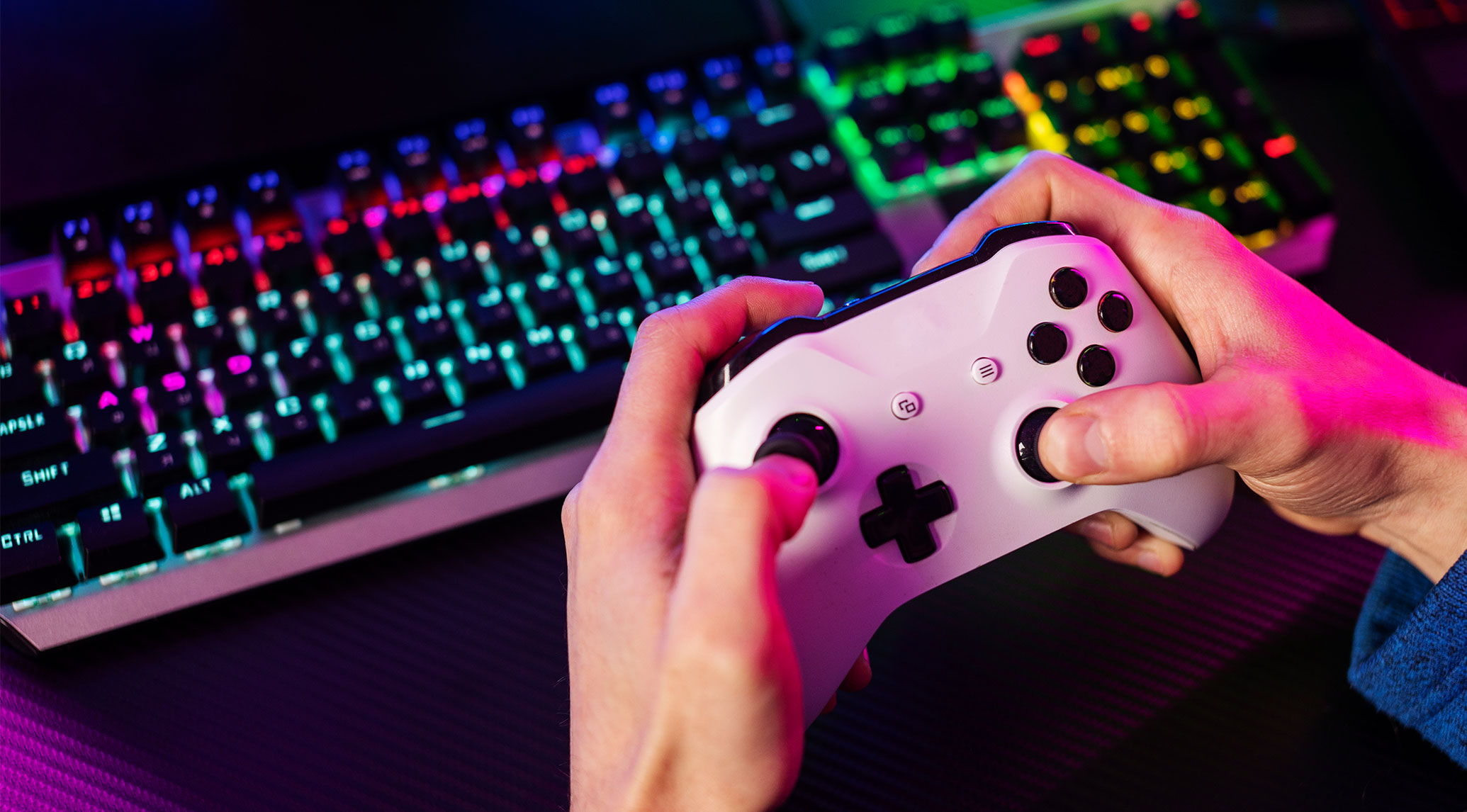 Gaming-Controller vor RGB-beleuchteter Tastatur – neue Chancen für Hörakustiker in der Gaming-Branche entdecken.